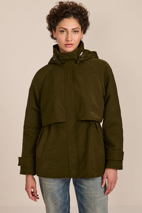 Women's hooded raincoat with drawstring waist, storm flap, side pockets and adjustable cuffs.