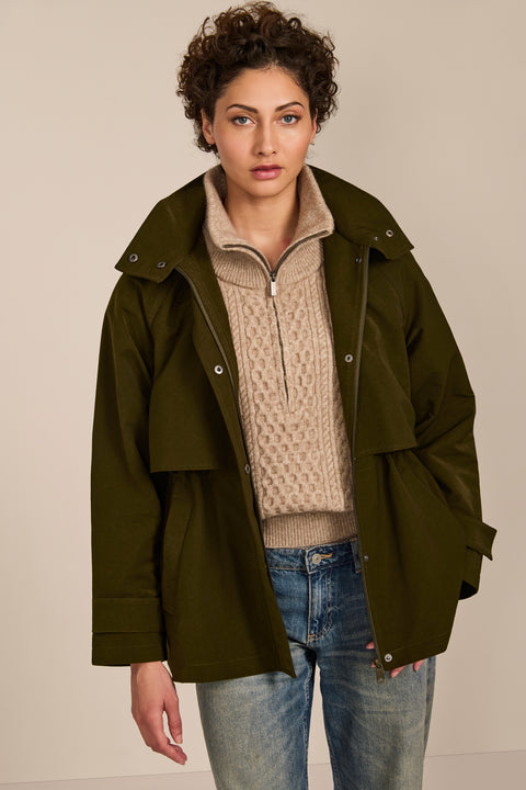 Women's hooded raincoat with drawstring waist, storm flap, side pockets and adjustable cuffs.