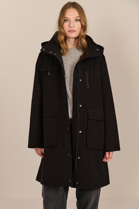 Women's black All-Weather Parka with an oversized hood, utility pockets and longline silhouette.