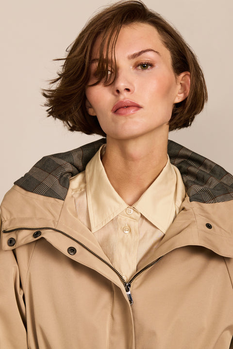Women's raincoat with drawstring waist and hood.