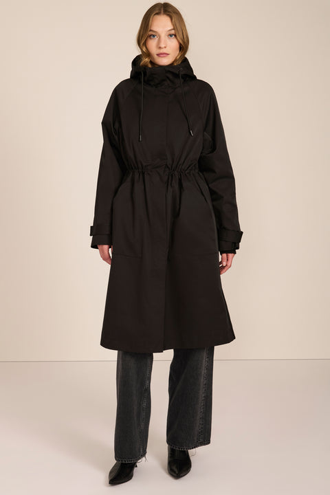 Women's water-repellent hooded raincoat with adjustable drawcord waist and patch pockets