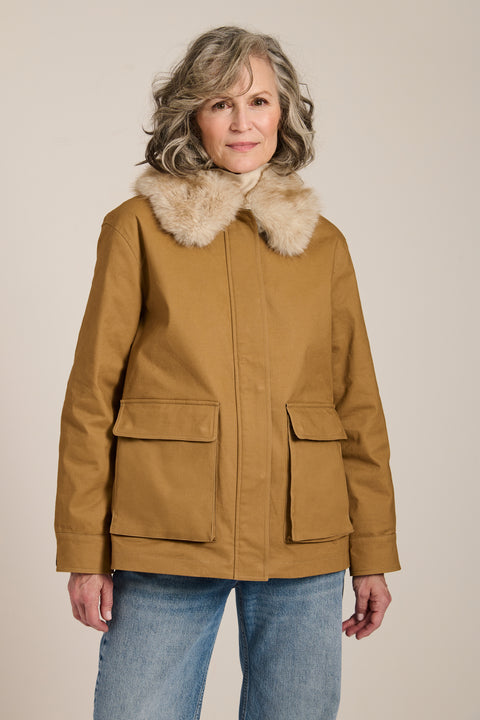 Utility jacket with removable faux fur collar, drawstring waist, oversized flap pockets and hidden zip closure.