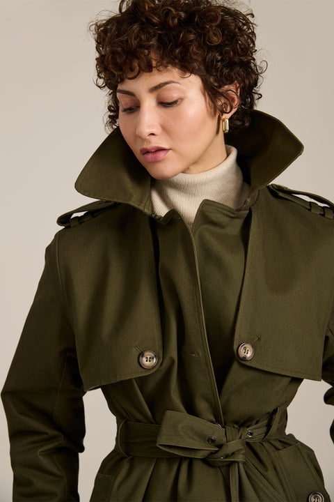 Women's belted trench coat with double-breasted front and water-repellent fabric.