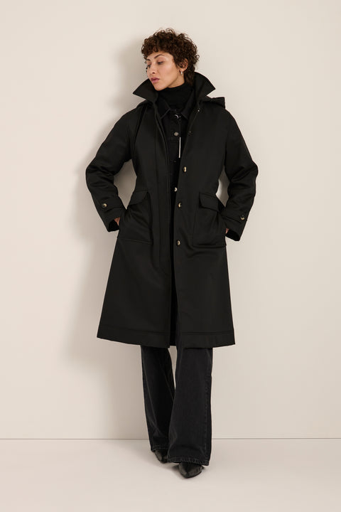 Women's belted raincoat with removable hood and water-repellent finish.