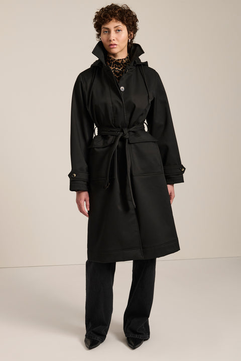 Women's belted raincoat with removable hood and water-repellent finish.