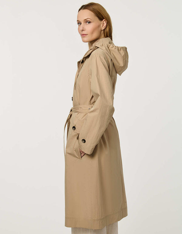 Women’s lightweight utility trench coat with belted waist, flap pockets, and roll-away hood tucked into the collar.