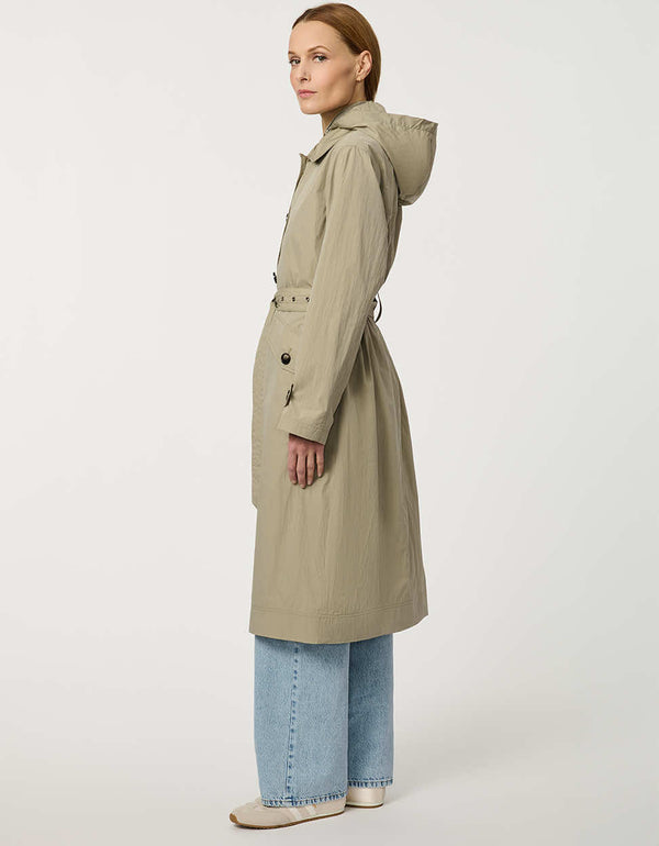 Women’s lightweight utility trench coat with belted waist, flap pockets, and roll-away hood tucked into the collar.