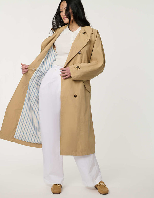 Women’s double-breasted trench coat with belted waist, cuff tabs, and striped interior lining.