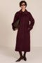 Women's long wool coat featuring a sculptural stand collar, concealed front closure, patch pockets, and button-tab cuffs.