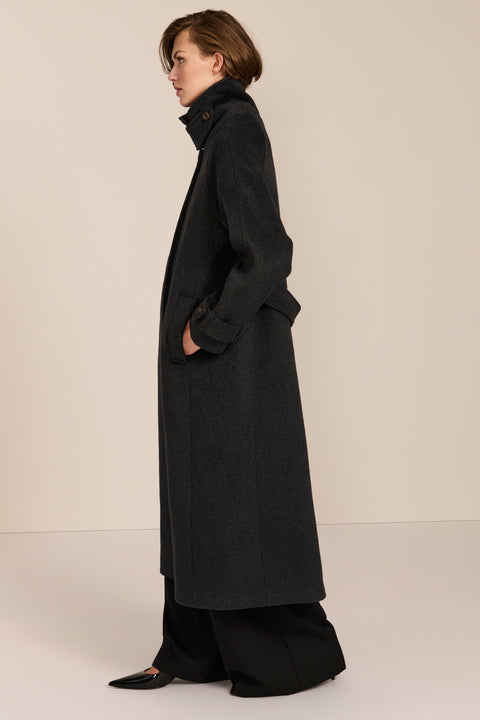Women's long wool coat featuring a sculptural stand collar, concealed front closure, patch pockets, and button-tab cuffs.