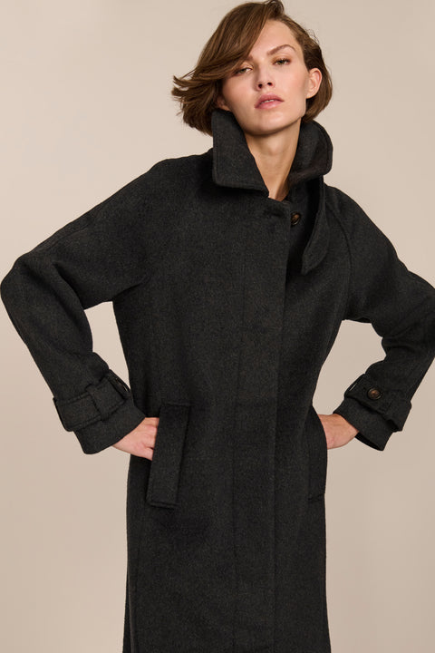 Women's long wool coat featuring a sculptural stand collar, concealed front closure, patch pockets, and button-tab cuffs.