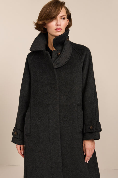 Women's long wool coat featuring a sculptural stand collar, concealed front closure, patch pockets, and button-tab cuffs.