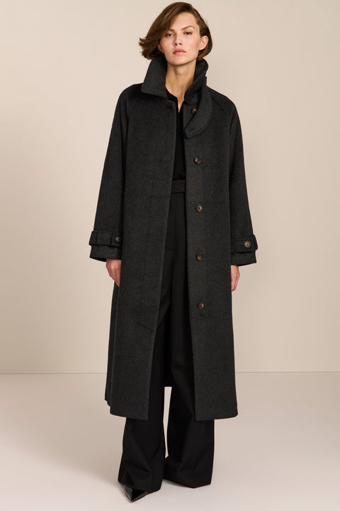 Women's long wool coat featuring a sculptural stand collar, concealed front closure, patch pockets, and button-tab cuffs.