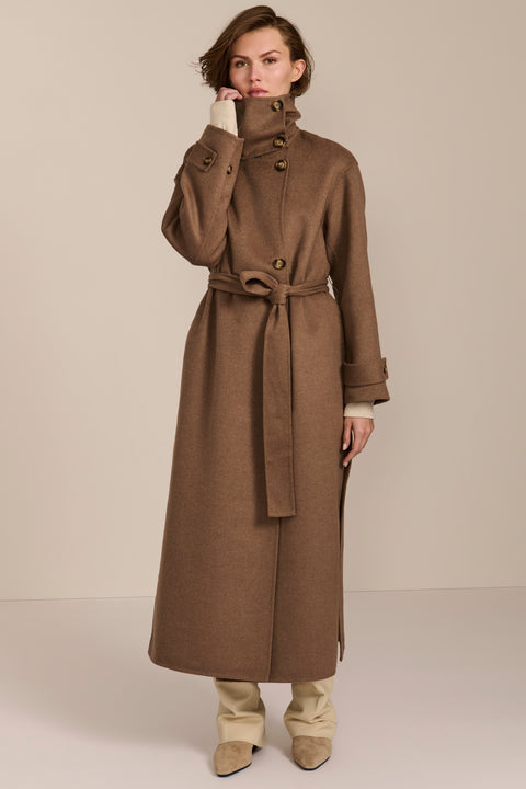 Women's long belted wool coat featuring a high stand collar, asymmetric button closure, wide cuffs and side slits.
