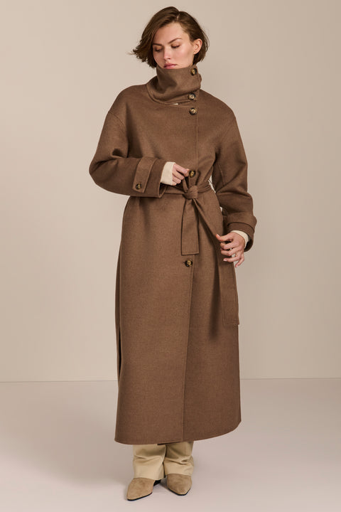 Women's long belted wool coat featuring a high stand collar, asymmetric button closure, wide cuffs and side slits.
