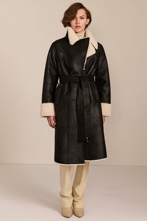 women's black faux shearling belted coat featuring ivory contrast trim, oversized notched collar, zip-front closure and zip pockets.