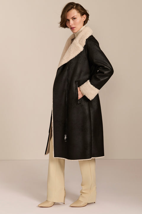 women's black faux shearling belted coat featuring ivory contrast trim, oversized notched collar, zip-front closure and zip pockets.