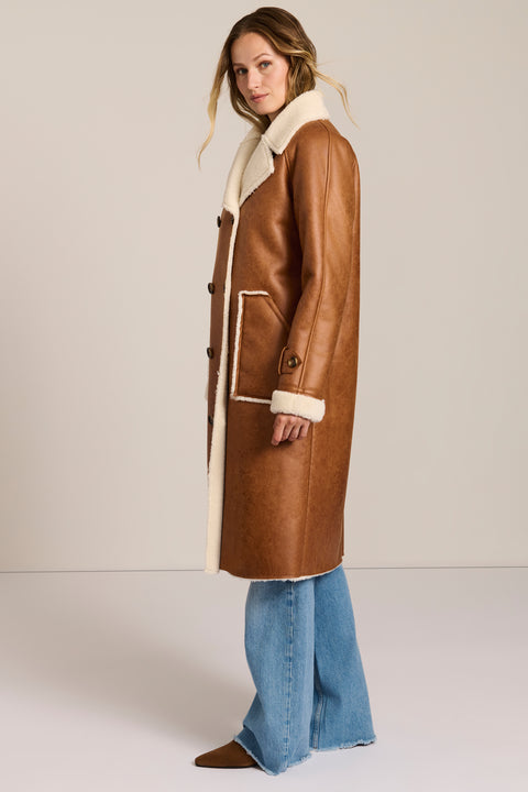 women's faux shearling coat featuring ivory contrast trim, an oversized notched collar, double-breasted button closure and patch pockets.