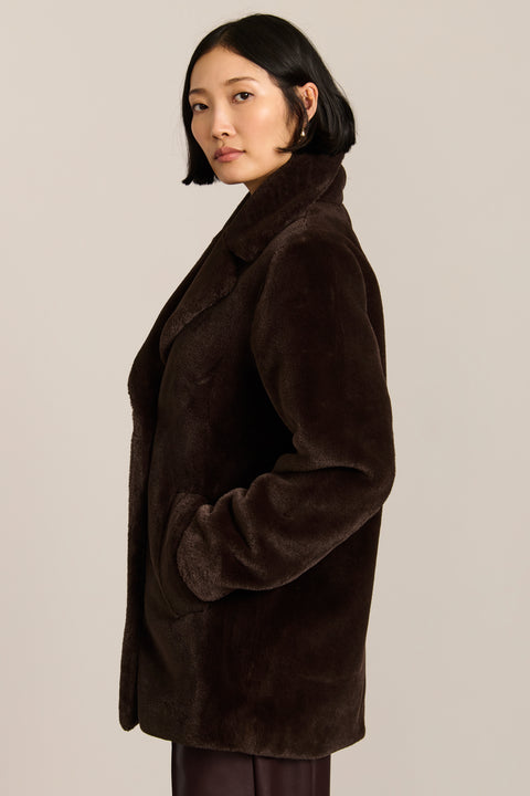 women's dark brown double-breasted faux fur coat with an oversized notched collar, button front, and angled pockets.