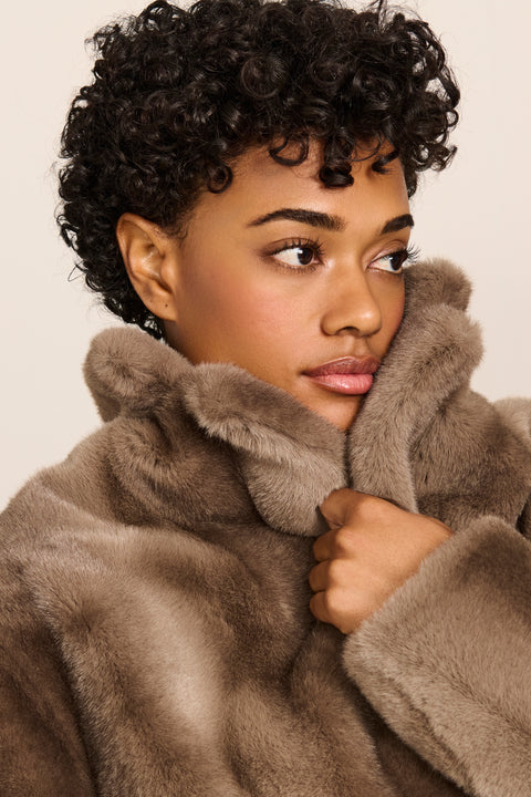 women's long taupe faux fur coat with a wide notched collar, single-breasted front, and side pockets.