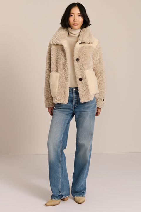 women's cream mixed-media teddy jacket with contrasting faux shearling textures, oversized patch pockets, button-front closure, and a plush stand collar.