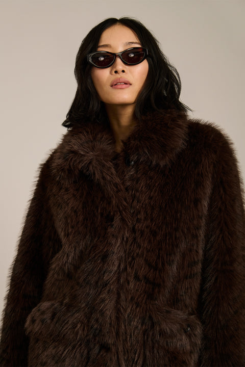 Spotted faux fur coat with oversized notch collar, button-front closure and patch pockets with side entry.