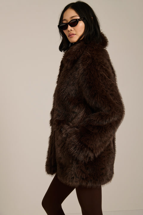 Spotted faux fur coat with oversized notch collar, button-front closure and patch pockets with side entry.