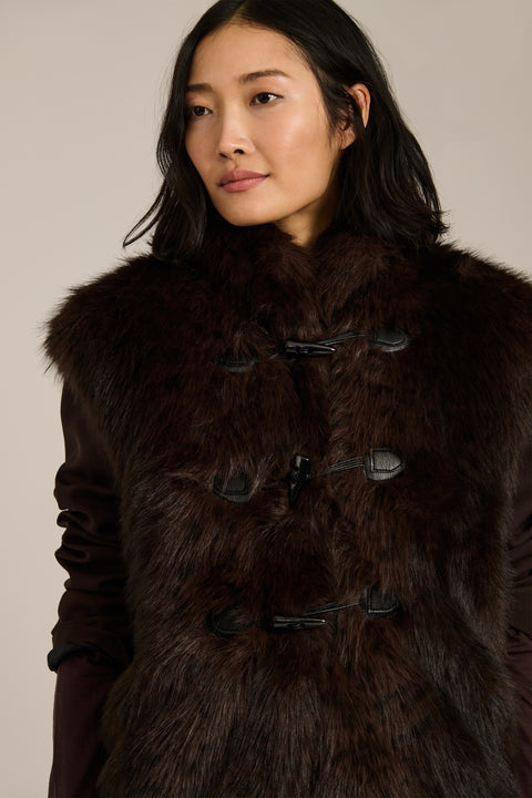 Women's faux fur vest with toggle closures, stand collar, and side pockets.