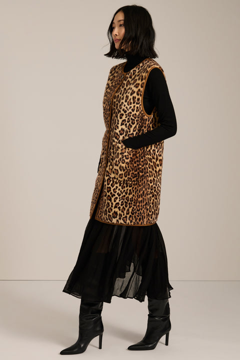 Long leopard print faux fur vest with collarless silhouette, faux leather trim and streamlined fit.