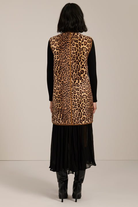 Long leopard print faux fur vest with collarless silhouette, faux leather trim and streamlined fit.