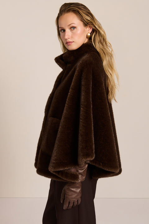 women's Faux Fur Cape Jacket in chocolate brown with a stand collar, sweeping cape sleeves and oversized patch pockets.