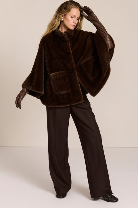 women's Faux Fur Cape Jacket in chocolate brown with a stand collar, sweeping cape sleeves and oversized patch pockets.