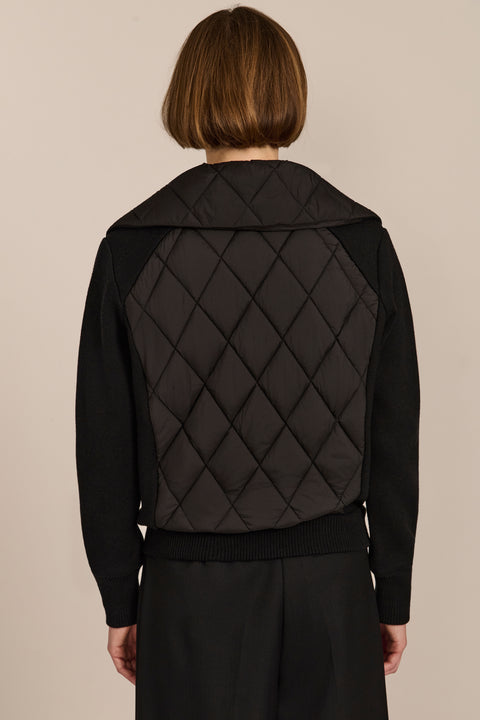 Women's quilted bomber jacket with knit sleeves.
