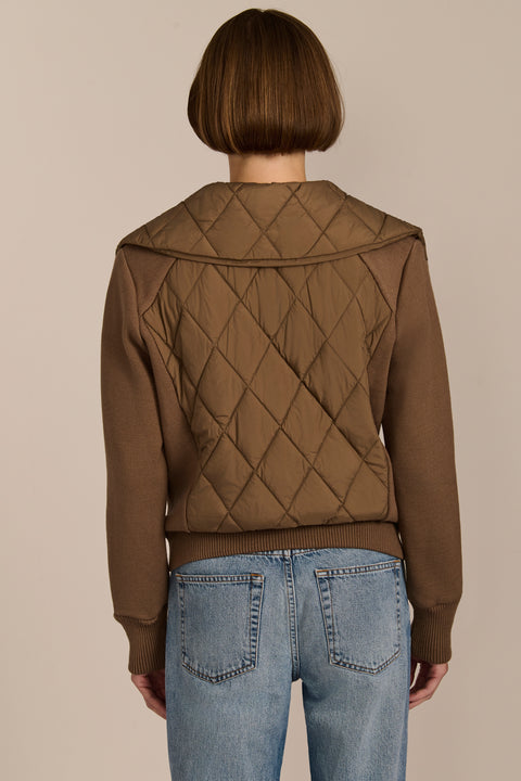 Women's quilted bomber jacket with knit sleeves.