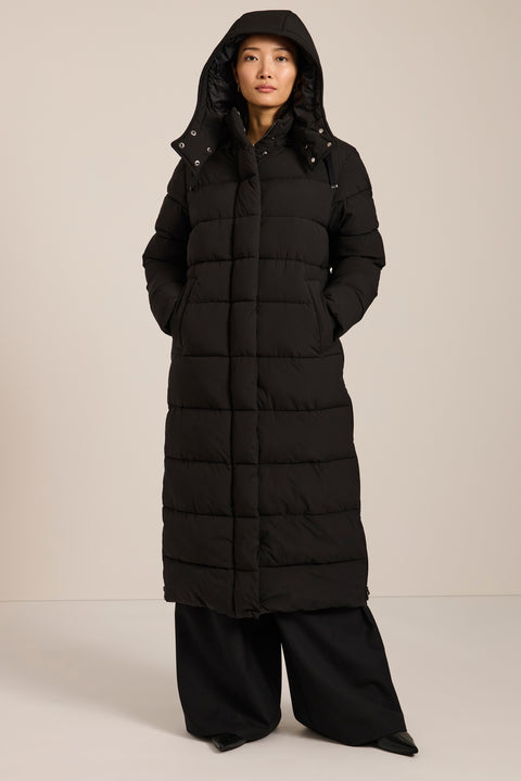 Long insulated puffer coat with removable hood, hidden placket, side zip vents and zippered pockets.