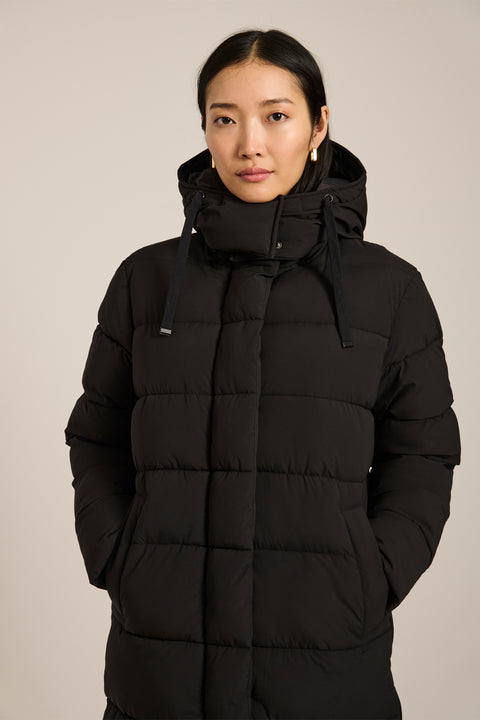 Long insulated puffer coat with removable hood, hidden placket, side zip vents and zippered pockets.
