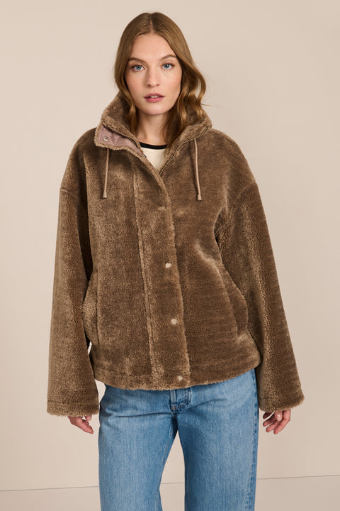 women's sherpa jacket featuring a high funnel collar, adjustable drawcords, concealed snap-front closure and side pockets.
