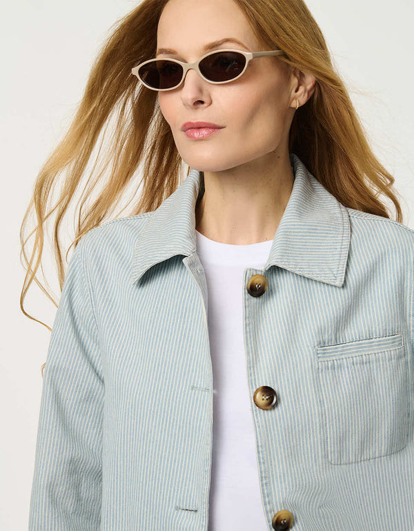 Women’s striped denim jacket with a relaxed fit and tortoise shell buttons.