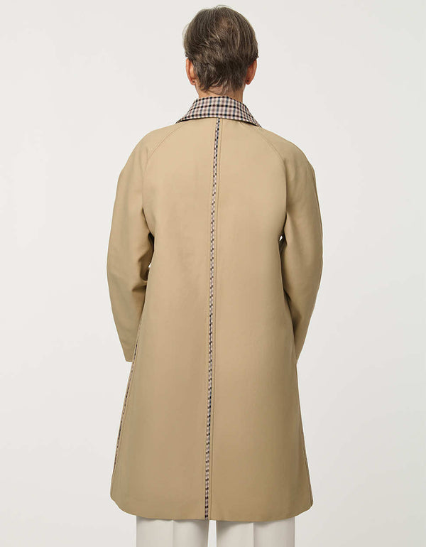 Women’s khaki trench coat with a streamlined silhouette, button front, side pockets, and contrasting plaid collar.