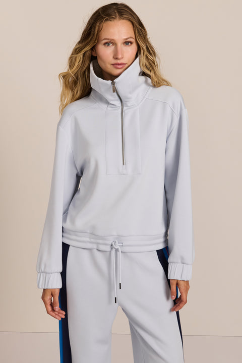 Sporty yet polished. Two ways to wear it, one effortlessly modern layer. Crafted from soft scuba fabric, this relaxed sweatshirt is elevated by a sculptural contrast collar and quarter-zip neckline. Ribbed cuffs and an easy silhouette bring laid-back appeal, while the unexpected colorblocking gives it a distinctly modern finish. The convertible collar can be worn open or zipped into a dramatic funnel neck, while a drawstring hem lets you play with the shape. Pair it with the coordinating pant for an effortl