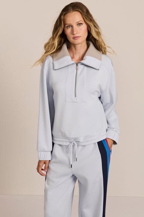 Sporty yet polished. Two ways to wear it, one effortlessly modern layer. Crafted from soft scuba fabric, this relaxed sweatshirt is elevated by a sculptural contrast collar and quarter-zip neckline. Ribbed cuffs and an easy silhouette bring laid-back appeal, while the unexpected colorblocking gives it a distinctly modern finish. The convertible collar can be worn open or zipped into a dramatic funnel neck, while a drawstring hem lets you play with the shape. Pair it with the coordinating pant for an effortl