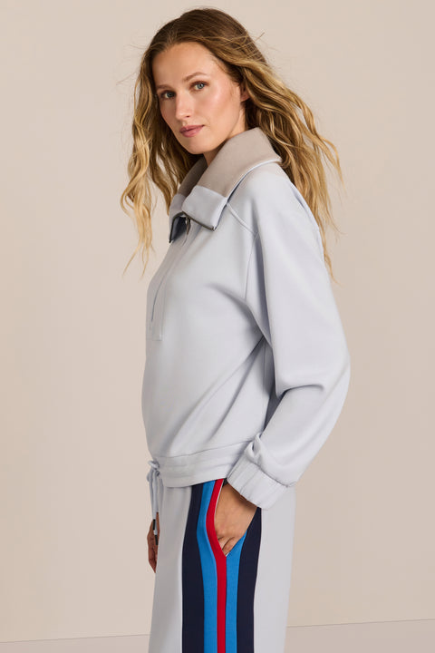 Sporty yet polished. Two ways to wear it, one effortlessly modern layer. Crafted from soft scuba fabric, this relaxed sweatshirt is elevated by a sculptural contrast collar and quarter-zip neckline. Ribbed cuffs and an easy silhouette bring laid-back appeal, while the unexpected colorblocking gives it a distinctly modern finish. The convertible collar can be worn open or zipped into a dramatic funnel neck, while a drawstring hem lets you play with the shape. Pair it with the coordinating pant for an effortl