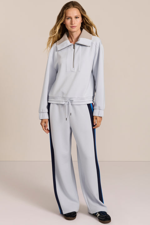 Sporty yet polished. Two ways to wear it, one effortlessly modern layer. Crafted from soft scuba fabric, this relaxed sweatshirt is elevated by a sculptural contrast collar and quarter-zip neckline. Ribbed cuffs and an easy silhouette bring laid-back appeal, while the unexpected colorblocking gives it a distinctly modern finish. The convertible collar can be worn open or zipped into a dramatic funnel neck, while a drawstring hem lets you play with the shape. Pair it with the coordinating pant for an effortl
