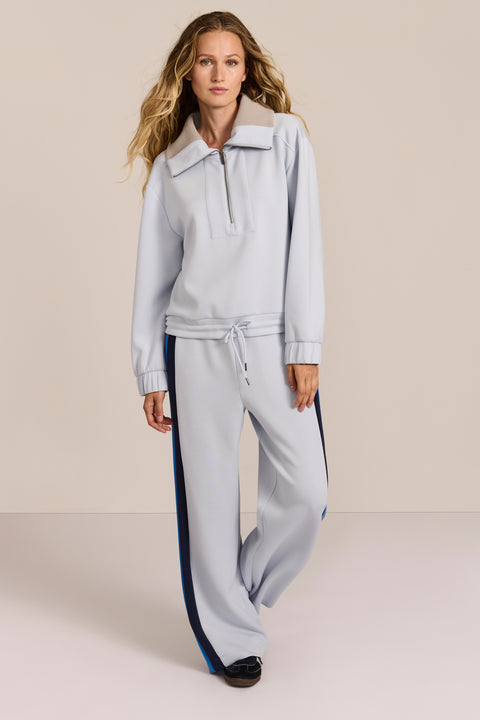 Sporty yet polished. Two ways to wear it, one effortlessly modern layer. Crafted from soft scuba fabric, this relaxed sweatshirt is elevated by a sculptural contrast collar and quarter-zip neckline. Ribbed cuffs and an easy silhouette bring laid-back appeal, while the unexpected colorblocking gives it a distinctly modern finish. The convertible collar can be worn open or zipped into a dramatic funnel neck, while a drawstring hem lets you play with the shape. Pair it with the coordinating pant for an effortl