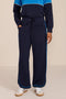 Women's soft scuba wide-leg pants with light blue piping, patch pockets, drawstring waist and side slits.