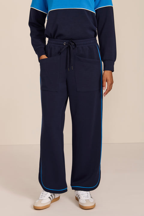 Women's soft scuba wide-leg pants with light blue piping, patch pockets, drawstring waist and side slits.