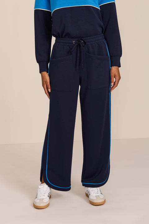 Women's soft scuba wide-leg pants with light blue piping, patch pockets, drawstring waist and side slits.