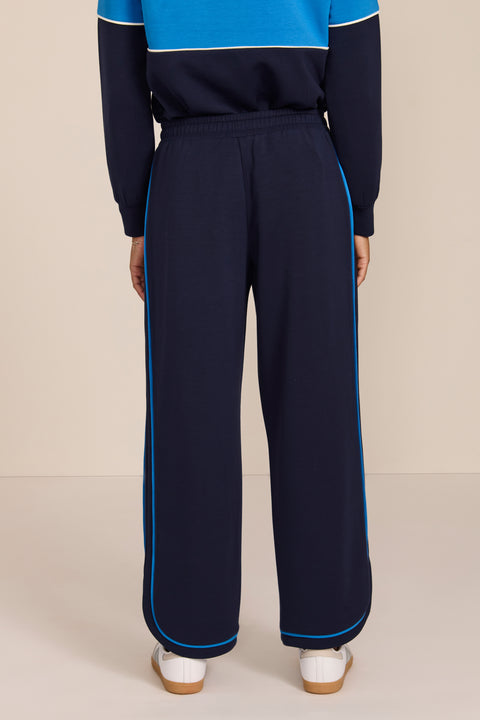 Women's soft scuba wide-leg pants with light blue piping, patch pockets, drawstring waist and side slits.
