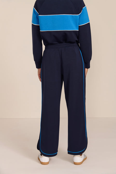 Women's soft scuba wide-leg pants with light blue piping, patch pockets, drawstring waist and side slits.