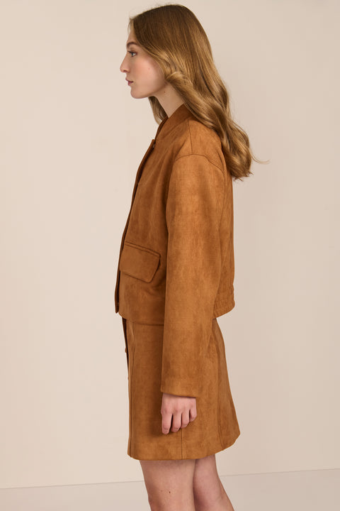 women's camel faux suede bomber jacket with a tonal snap front and flap pockets, styled with the coordinating mini skirt.